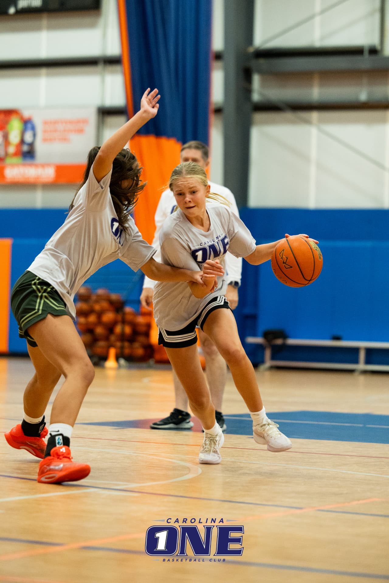 Carolina One Basketball athlete driving past a defender in practice